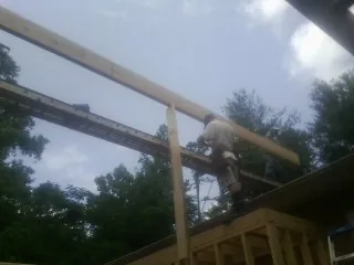 Carpenter setting a ridge beam over a new addition frame — Ice Dam Removal by Roofing Brothers in Champlin