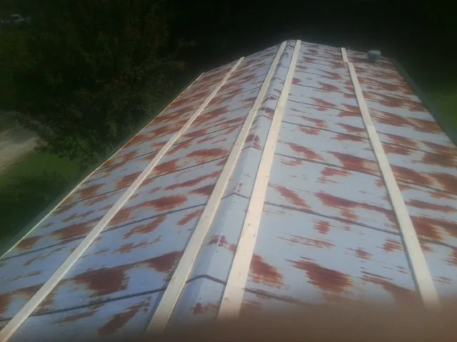 Rusted metal roof panels with new wood purlins before replacement — Storm Damage Roof Repair in Champlin by Roofing Brothers