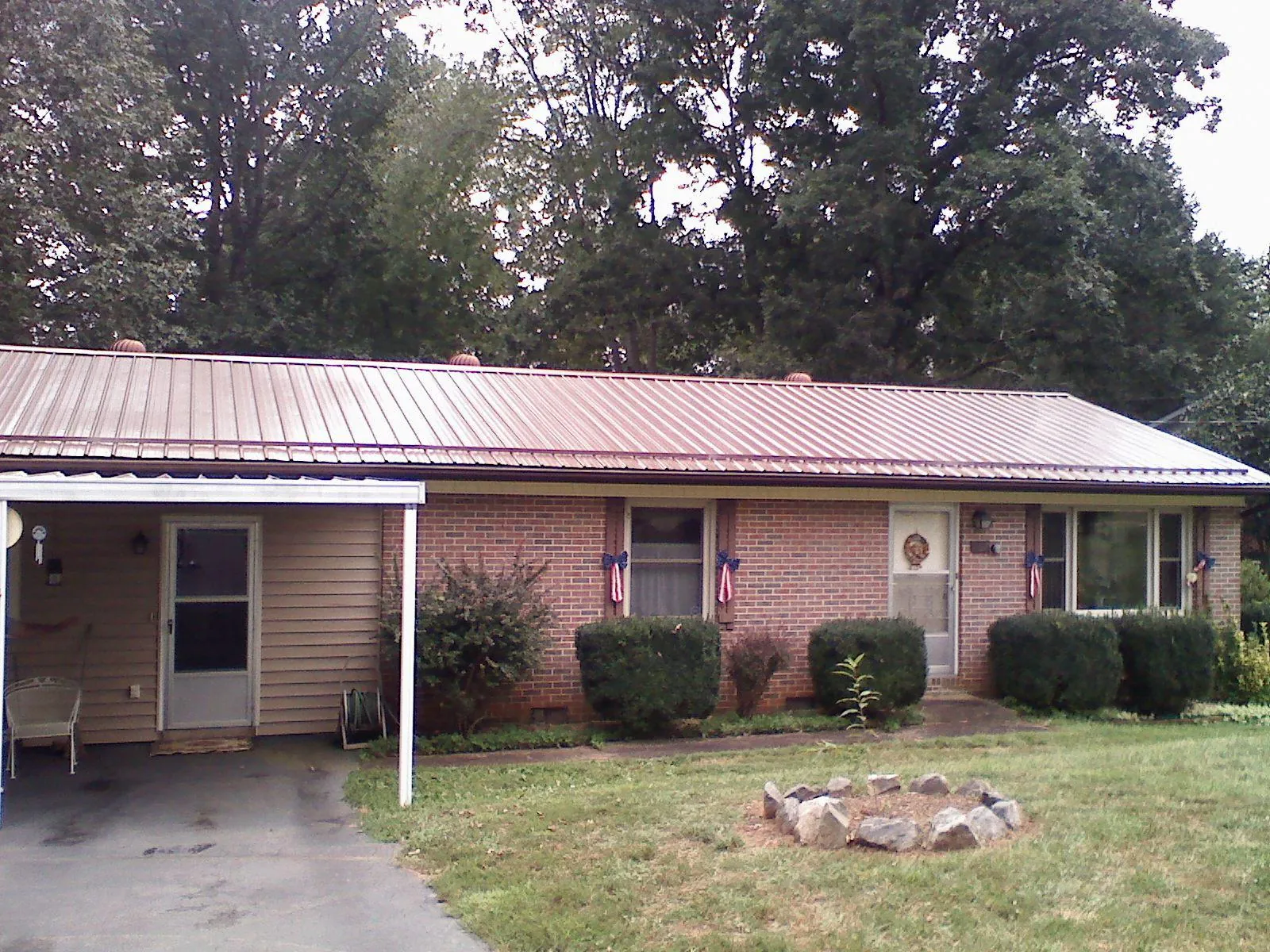 Bronze metal roof and carport on a brick ranch home — Roof Repair work by our crew in Champlin