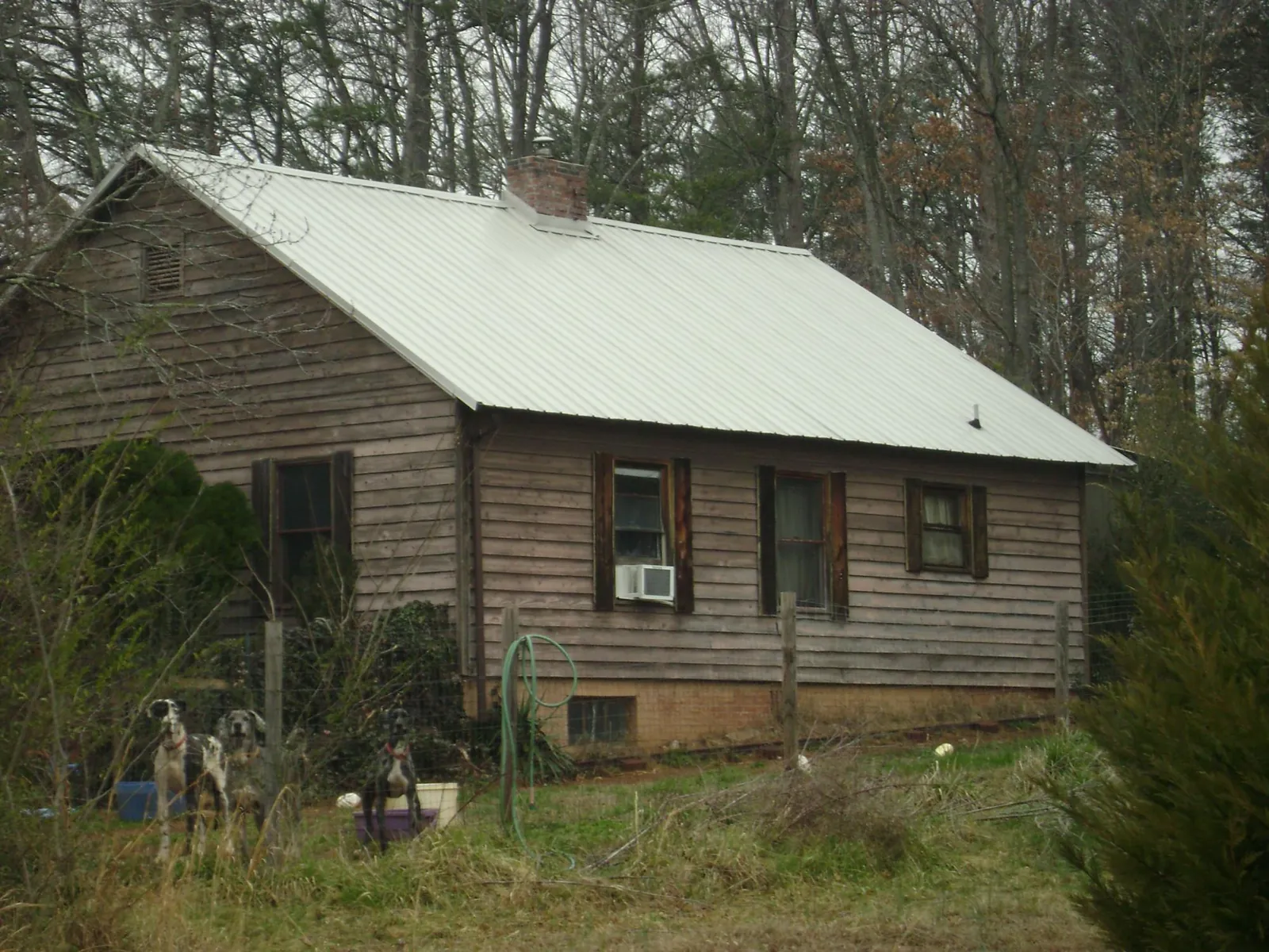 White metal roof on an old wood sided farmhouse, from a Metal Roof Installation job in Champlin